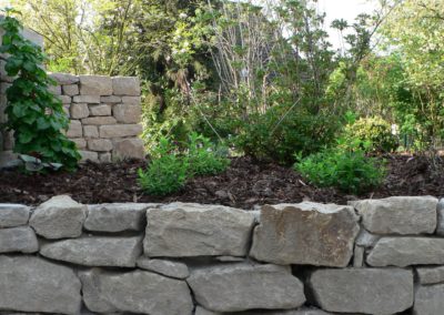 Natursteinmauer mit Bepflanzung